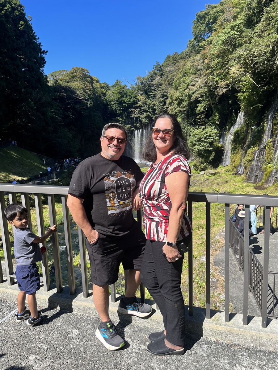 Couple viewing Shiraito Falls from a short distance, enjoying the natural beauty.